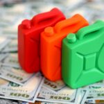 Diesel Record Shatters – Wallets Hit Hard Three colorful plastic containers on a background of hundred dollar bills