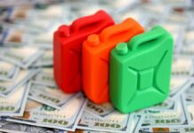 Three colorful plastic containers on a background of hundred dollar bills
