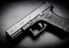 Black Glock 19 pistol on a dark surface.