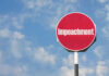 Red sign with the word Impeachment against sky