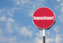 Impeachment Bombshell Hits Pentagon Red sign with the word Impeachment against sky