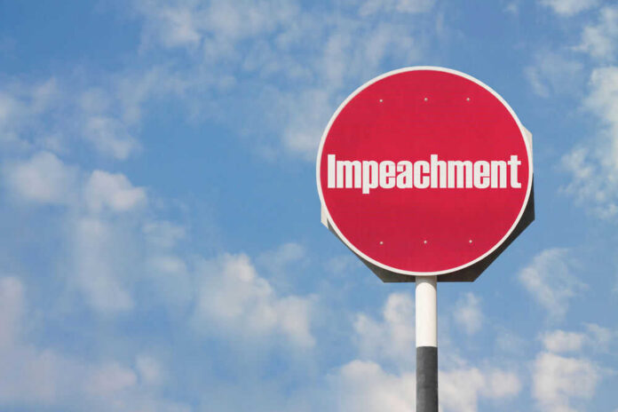 shutterstock_491384413 Red sign with the word Impeachment against sky