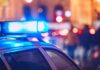 Mother’s Drunken Night Ends With Dead Infant Close-up of a police car with blue emergency lights in a city at night