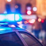 Mother’s Drunken Night Ends With Dead Infant Close-up of a police car with blue emergency lights in a city at night
