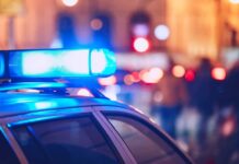 Mother’s Drunken Night Ends With Dead Infant Close-up of a police car with blue emergency lights in a city at night