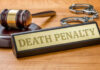 Double Dose, Inmate Lives Gavel handcuffs and death penalty sign on table