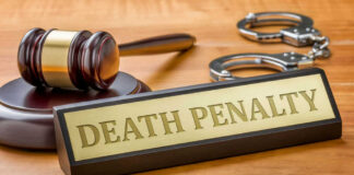 Gavel handcuffs and death penalty sign on table