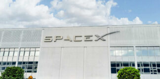 SpaceX building with logo and blue sky.