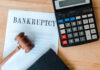 Bankruptcy document with gavel and calculator on desk