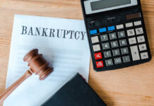 Bankruptcy document with gavel and calculator on desk