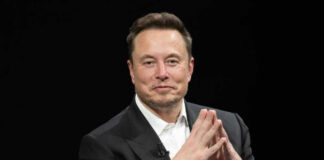 Elon Musk in a suit talking.