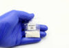 Killer Opioid Outruns Fentanyl Hand in glove holding fentanyl packet with skull warning.
