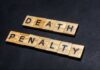Death Chamber Fails – Governor Slams Brakes Wooden letter tiles spelling DEATH PENALTY on a dark background