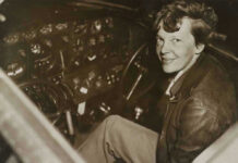 Amelia Earhart Clue Emerges Amelia Earhart seated in an airplane cockpit, looking toward the camera