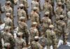 Timmy Jernigan among soldiers marching in formation on a street