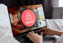 Hands using a laptop with Airbnb app on screen