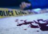 Midtown Platform Chaos – One Shot, One Dead Blood on pavement with police tape and a hand in the background