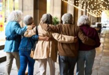 Longevity Trick Hiding In Plain Sight Group of elderly friends walking arm in arm outdoors