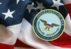 Department of War emblem on an American flag background