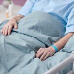Hospital Got It Wrong? MS Mislabels Exposed Patient resting in a hospital bed with hands on blanket