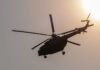 Helicopter silhouette flying near the sun