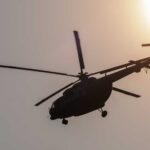 Helicopter silhouette flying near the sun