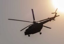Helicopter silhouette flying near the sun