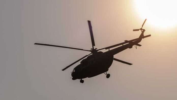 Silhouette,Of,A,Helicopter,Flying,Against,A,Glowing,Sun,,Creating Helicopter silhouette flying near the sun