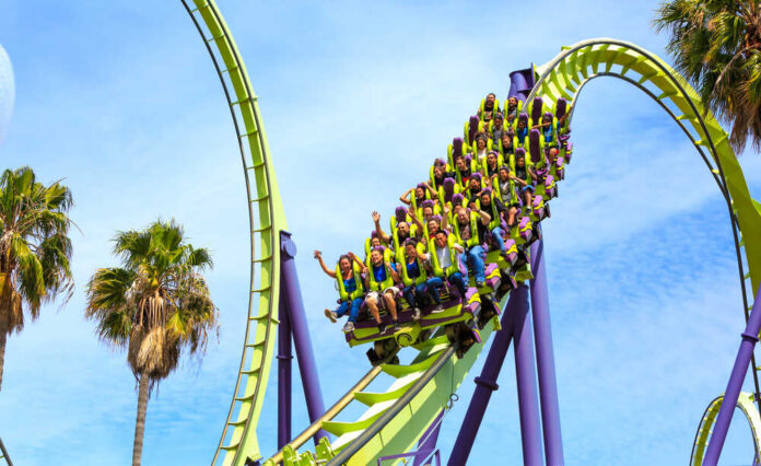 Roller coaster riders on a green and purple loop
